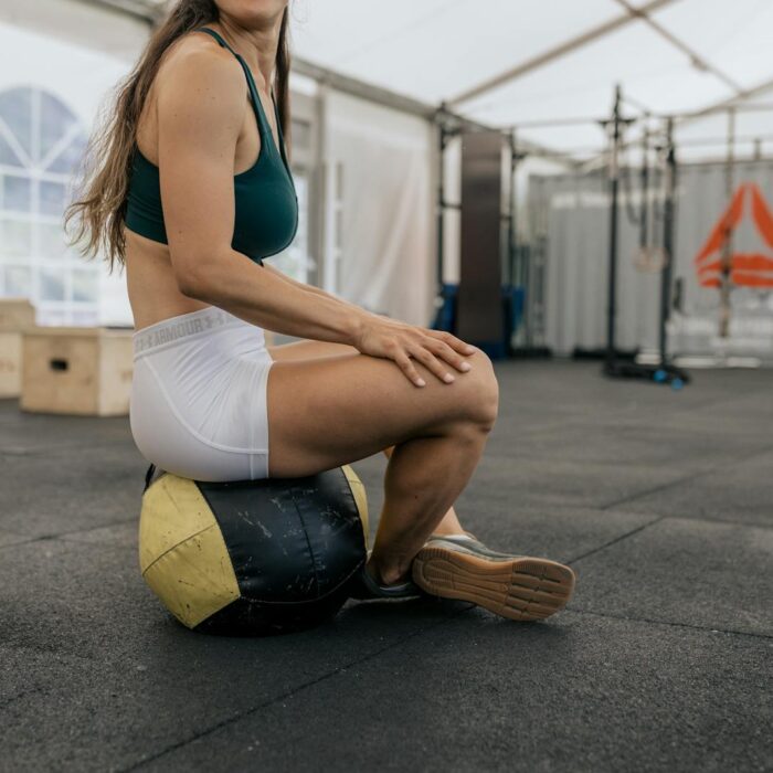 Woman Sitting on a Medicine Ball